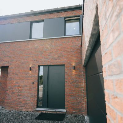 construction clé sur porte dans le brabant wallon en belgique avec une brique rouge et un joint noir et menuiseries extérieures noires