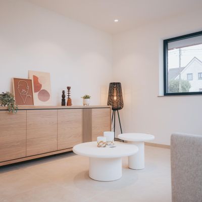 deuxième salon plus cosy avec mobilier en bois massif très clair et chassis noir à l'intérieur